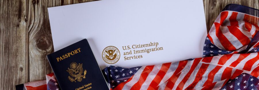 USA passport and citizenship naturalization certificate of US flag over wooden background